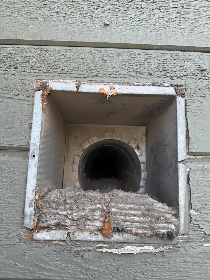 Clogged dryer vent packed with lint before cleaning